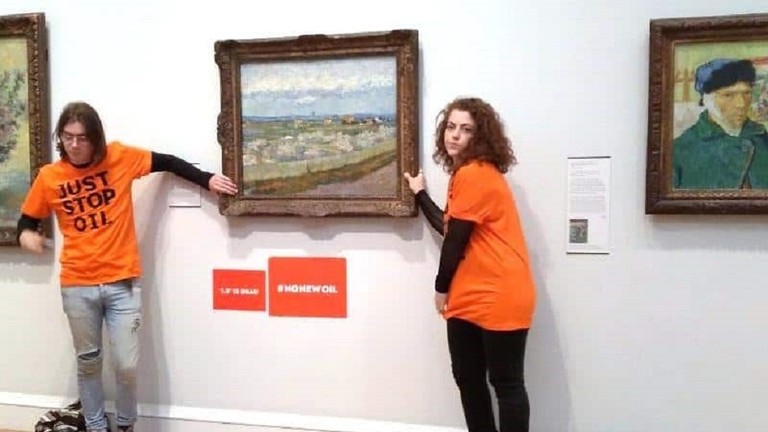Louis McKechnie (solda) ve Emily Brockbank kendilerini Londra, İngiltere'deki Courtauld Galerisi'nde Vincent Van Gogh'un 'Peach Trees in Blossom' tablosuna yapıştırıyorlar, 30 Haziran 2022
